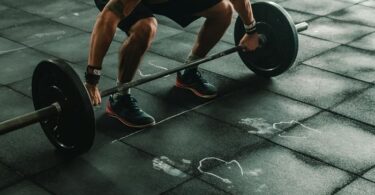 Pre-workout supplements - A man lifting a weight in a gym Pre-workout supplements