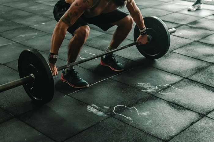 Pre-workout supplements - A man lifting a weight in a gym Pre-workout supplements